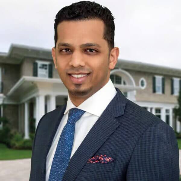 Professional man in suit smiling in front of luxury house, business portrait, real estate agent, executive profile photo.