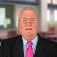Businessman in suit and pink tie standing in an office setting, professional portrait for corporate website or LinkedIn profile.
